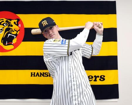 入団会見でポーズを決めるキャム・ディベイニー（撮影・山口登）