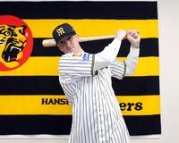 入団会見でポーズを決めるキャム・ディベイニー（撮影・山口登）