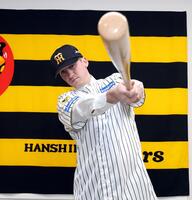 入団会見でポーズを決めるキャム・ディベイニー（撮影・山口登）