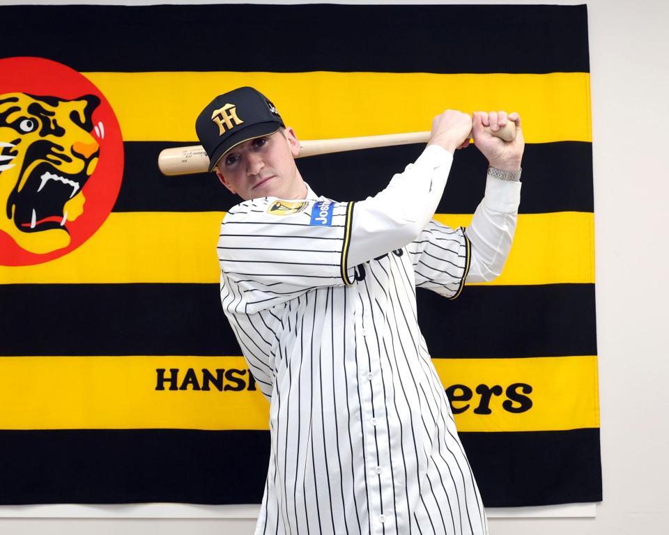 入団会見でポーズを決めるキャム・ディベイニー（撮影・山口登）