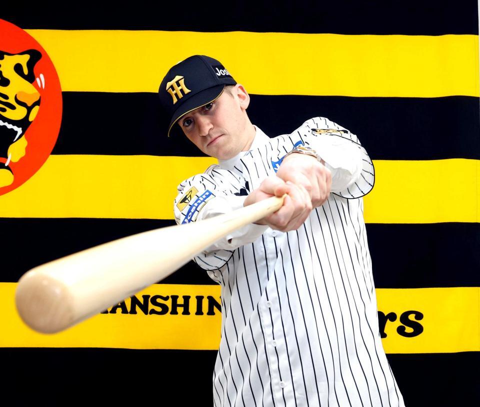 　入団会見でポーズを決めるディベイニー（撮影・山口登）