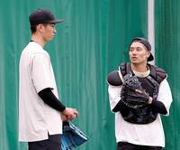 　ブルペン投球を終え、坂本（右）と言葉を交わす今朝丸