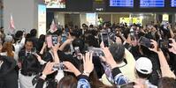 ファンが殺到する中、沖縄入りする佐藤輝（中央奥）＝撮影・飯室逸平