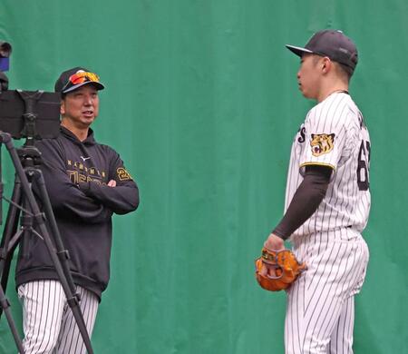 ブルペンで石井（右）に声をかける藤川監督（撮影・西田忠信）