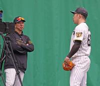 ブルペンで石井（右）に声をかける藤川監督（撮影・西田忠信）