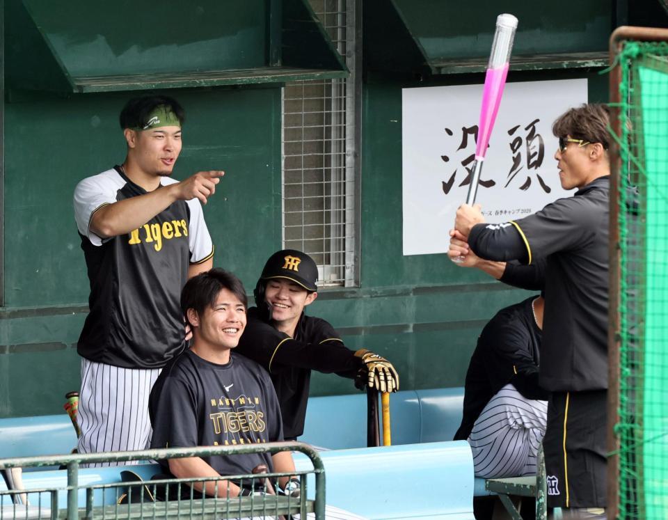 糸井臨時コーチが持つアクアバットに興味を示す佐藤輝（撮影・田中太一）