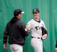 初ブルペンを終え、藤川監督（左）とグータッチするルーカス（撮影・西田忠信）