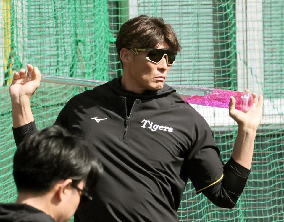 アクアバットを肩に担ぐ糸井嘉男臨時コーチ＝宜野座（撮影・田中太一）