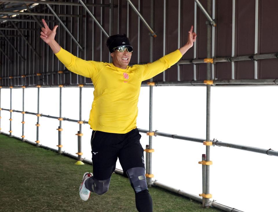 練習後、めんそー路を走り、両手を広げる糸井嘉男臨時コーチ＝宜野座（撮影・田中太一）