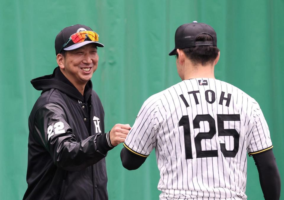 ブルペンで伊藤稜（右）に笑顔で声をかける藤川監督（撮影・西田忠信）