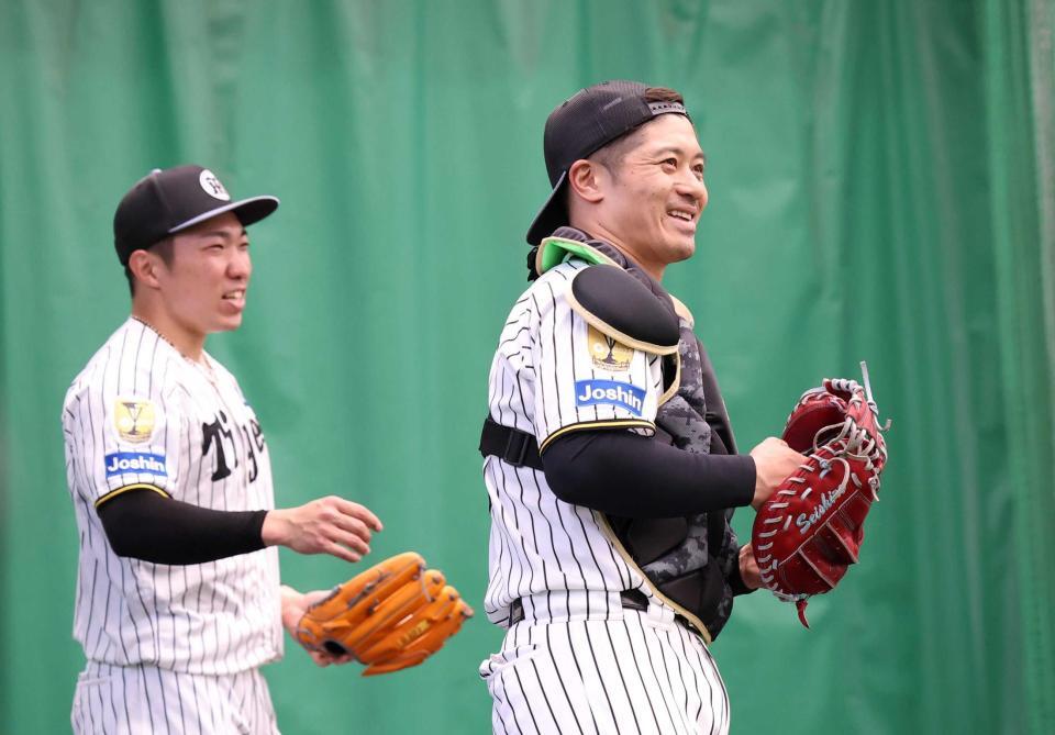 　ブルペン投球を終えた石井（左）と笑顔で言葉を交わす坂本（撮影・西田忠信）