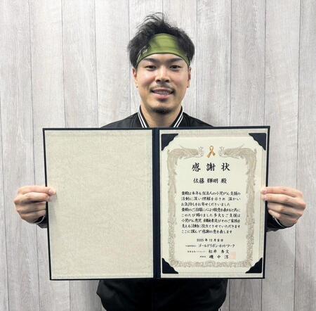 　感謝状を手にする佐藤輝（球団提供）