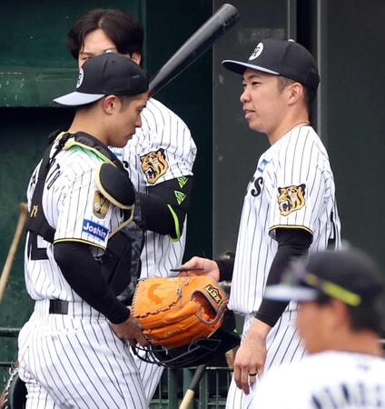 　登板を終え、坂本（左）と言葉を交わす石井