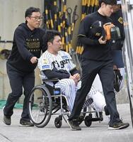 車椅子で球場を後にする石井