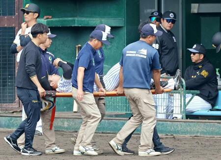 　担架で運ばれる石井。右端は藤川監督（撮影・立川洋一郎）