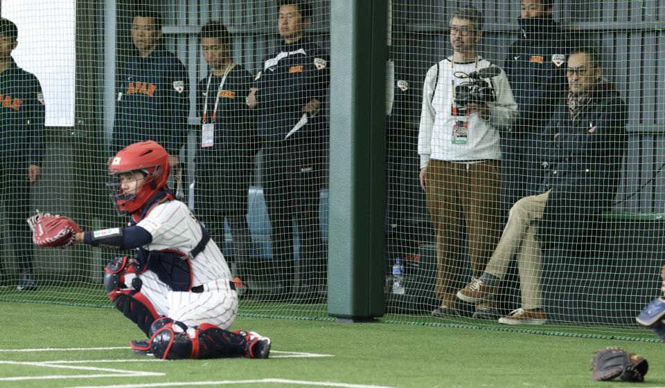 坂本誠志郎（手前）のキャッチングを見つめる渡辺謙（撮影・伊藤笙子）