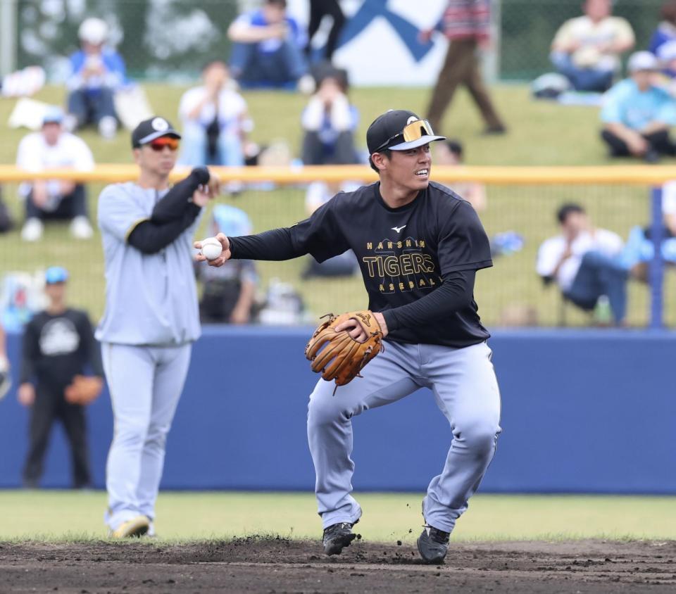 試合前、ノックを受ける谷端（左は藤川監督）＝撮影　山口登