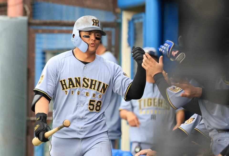 ７回、猛打賞となる安打を放ち、交代を告げられたベンチでナインとタッチをかわす（撮影・坂部計介）