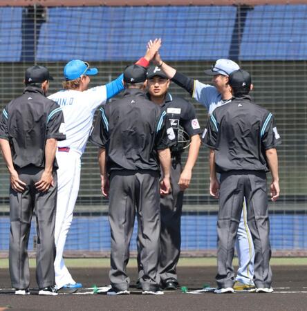 メンバー表を交換しハイタッチする新庄監督と藤川監督（撮影・山口登）