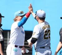 メンバー表交換時に、藤川監督（右）とハイタッチする新庄監督（撮影・西田忠信）