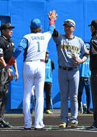 メンバー表の交換で新庄監督（左）とハイタッチを交わす藤川監督（撮影・持木克友）
