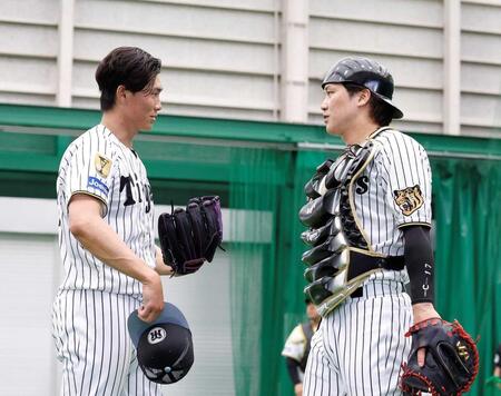 　ブルペン投球を終えた湯浅（左）と話をする伏見（撮影・西田忠信）