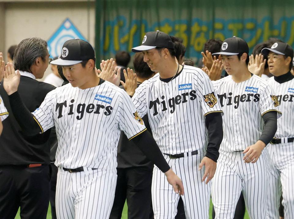 春季キャンプを打ち上げ、関係者らとハイタッチする（左から）嶋村、藤川監督、石黒（撮影・西田忠信）