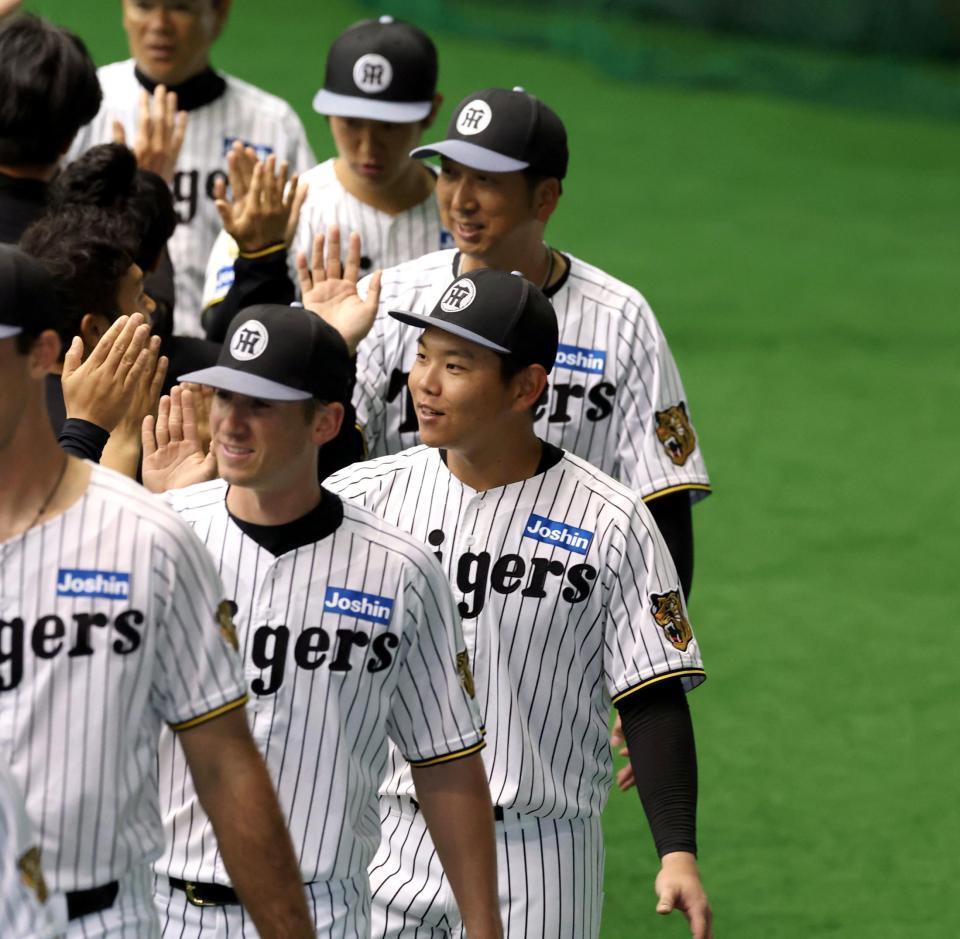 キャンプを打ち上げ、スタッフとハイタッチする嶋村（中央）＝撮影・山口登