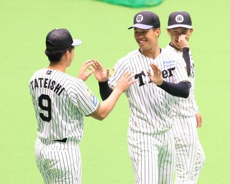 具志川キャンプを打ち上げ、立石（９）とハイタッチをかわす岡城（右は山崎）＝撮影・坂部計介