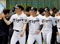 　キャンプを打ち上げ、関係者らと笑顔でハイタッチする村上（中央）＝撮影・西田忠信