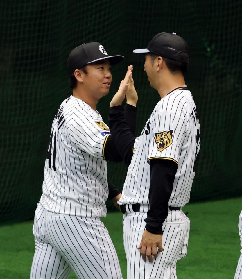 キャンプを打打ち上げ、村上（左）は藤川監督とハイタッチする（撮影・山口登）