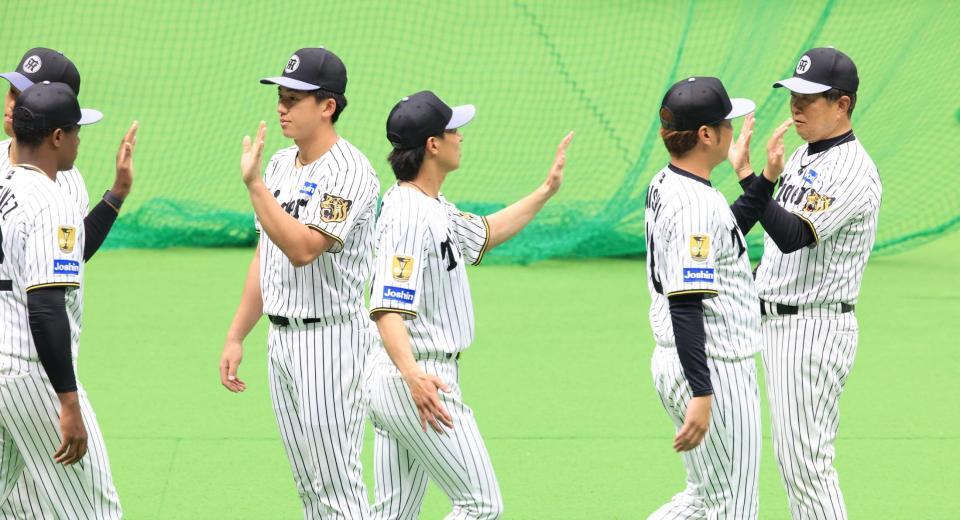 具志川キャンプを打ち上げ、ナインとハイタッチをかわす平田２軍監督（右端）と立石（左から３人目）＝撮影・坂部計介