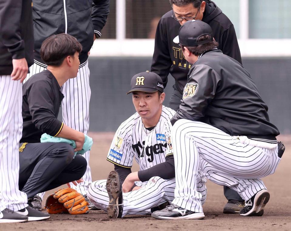 紅白戦の３回、左脚を痛めた仕草を見せる石井＝２月１１日