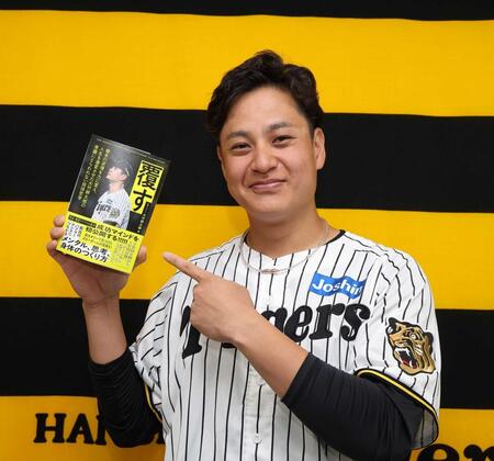 　自著を指さす大竹（撮影・西田忠信）