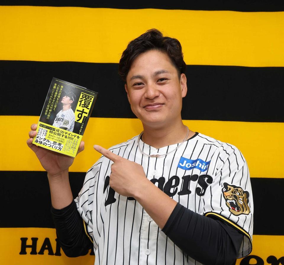 　自著を指さす大竹（撮影・西田忠信）