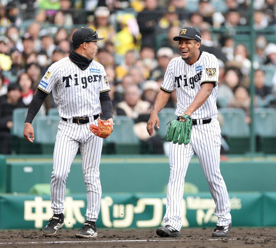 ８回の投球後、３塁ベンチに戻ろうとして佐野（左）に指摘され、思わず笑うモレッタ（撮影・西田忠信）