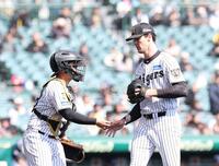 初回を投げ終え、嶋村（左）とタッチを交わすラグズデール（撮影・西田忠信）