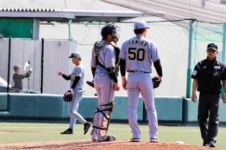 ３回無死一、三塁のピンチを背負い、捕手の梅野（左）と話し込む富田