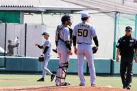 ３回無死一、三塁のピンチを背負い、捕手の梅野（左）と話し込む富田