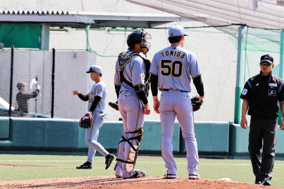 ３回無死一、三塁のピンチを背負い、捕手の梅野（左）と話し込む富田