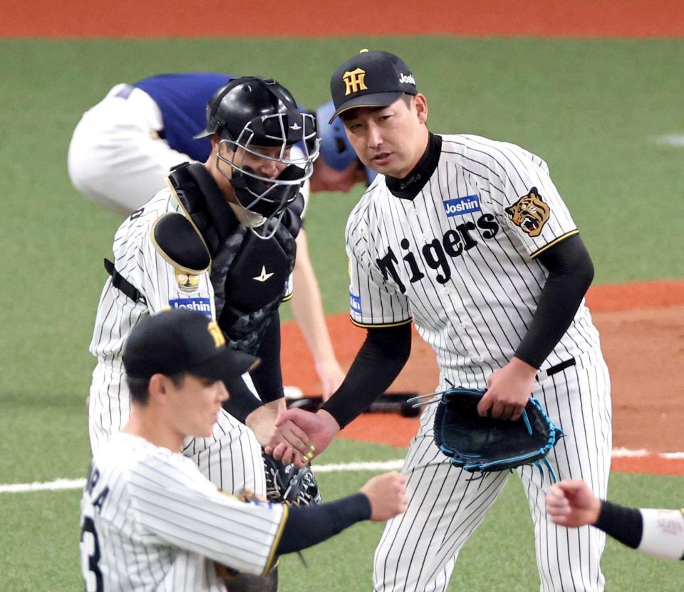 　試合を締め、坂本（左）と握手する岩崎（撮影・山口登）