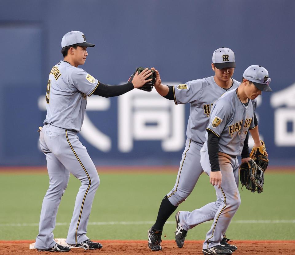 勝利後、タッチを交わす立石（左）ら外野手陣（撮影・西田忠信）