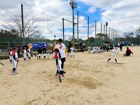 野球教室で指導し、こどもとハイタッチをする糸井ＳＡ＝提供写真