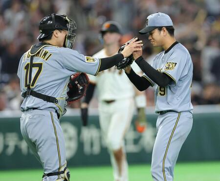 完封勝利で伏見（左）とタッチを交わす高橋（撮影・西岡正）