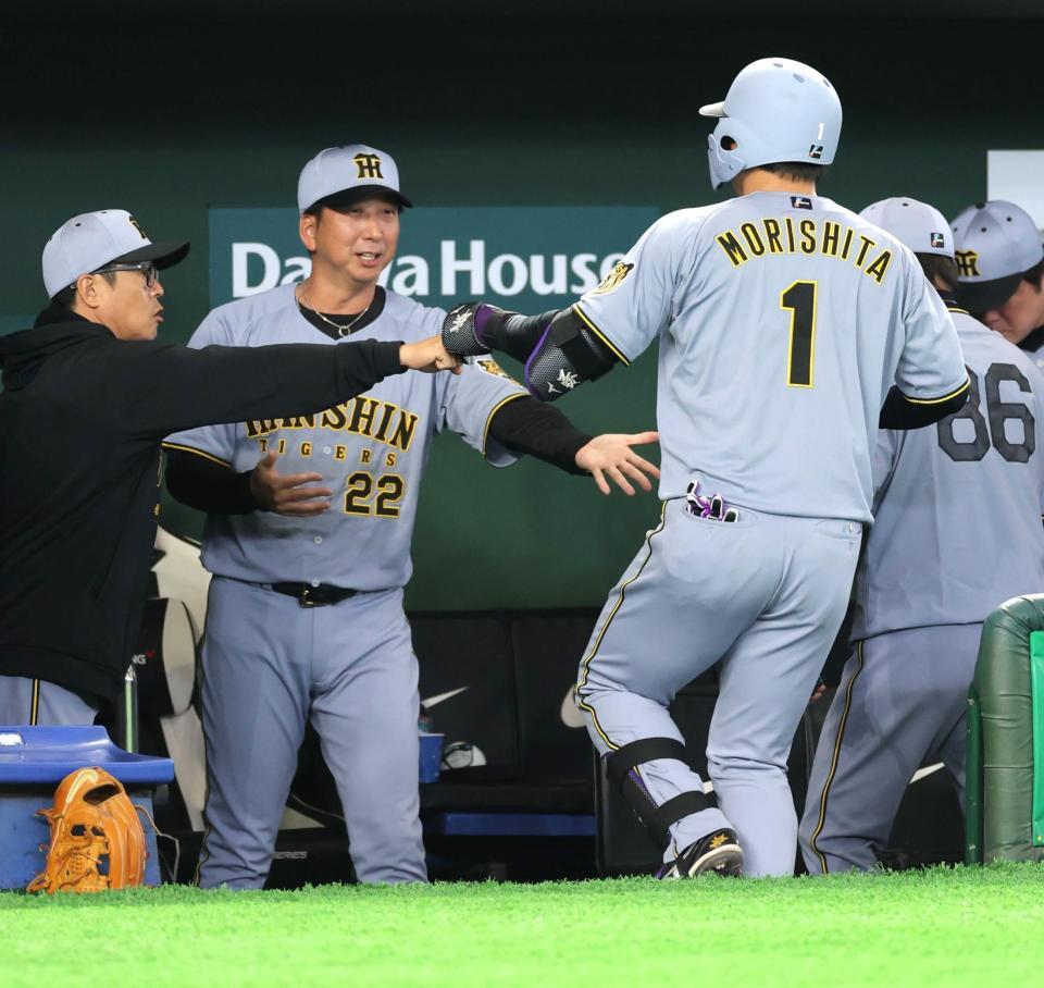 １回、先制の左犠飛を放った森下（右）を迎える藤川監督（撮影・西岡正）