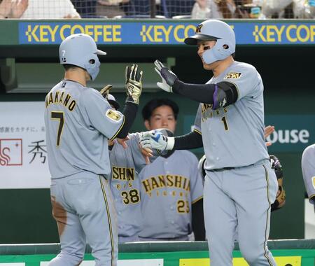 １回、先制の左犠飛を放ち、中野（左）とタッチを交わす森下（撮影・西岡正）