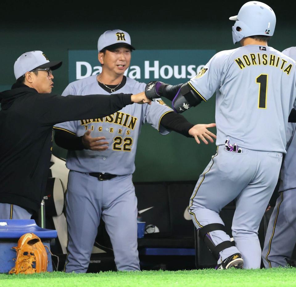 １回、先制の左犠飛を放った森下（右）を迎える藤川監督（撮影・西岡正）