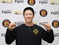 支配下登録され、笑顔でポーズを決める福島（撮影・山口登）