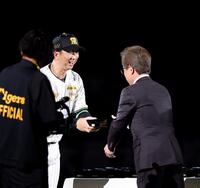 粟井球団社長（右）からチャンピオンリングを受け取る藤川監督（撮影・西田忠信）