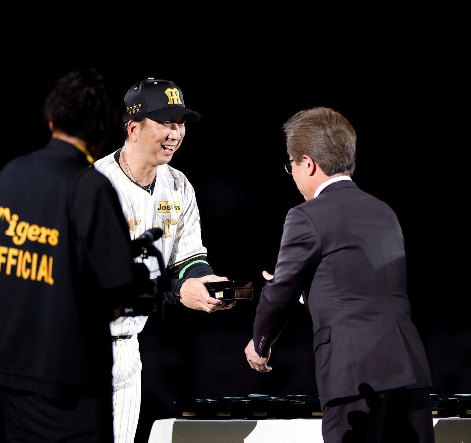 粟井球団社長（右）からチャンピオンリングを受け取る藤川監督（撮影・西田忠信）